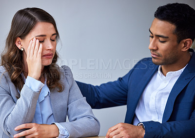 Buy stock photo Shot of a young man comforting his colleague at work
