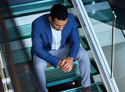 Buy stock photo Shot of a young man sitting on the stairs at work