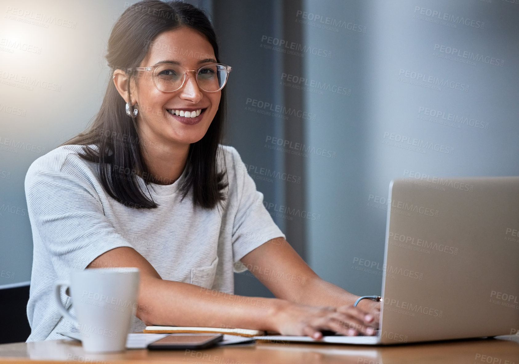 Buy stock photo Shot of a young woman having coffee and working in a modern office