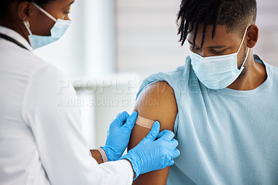 Buy stock photo Shot of a doctor applying a plaster to her patients arm