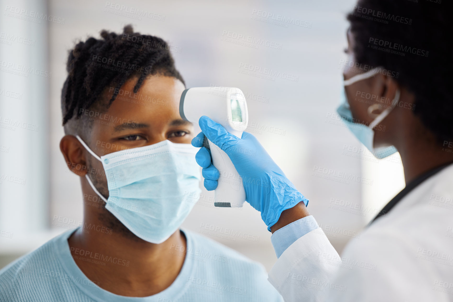 Buy stock photo Shot of a female doctor taking the temperature of her patient