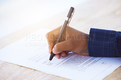 Buy stock photo Shot of an unrecognizable businessman filling in a form on a desk in an office