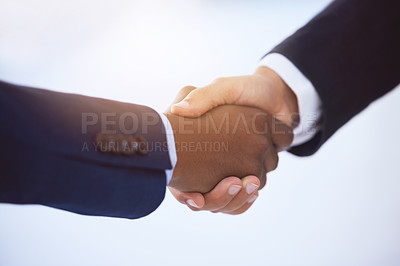 Buy stock photo Shot of two unrecognizable businessmen shaking hands against a blurry white background