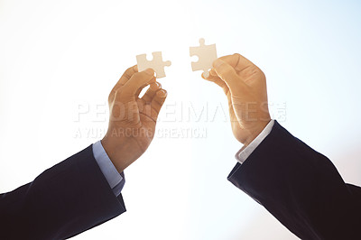 Buy stock photo Cropped shot of two unrecognizable businessmen completing a puzzle