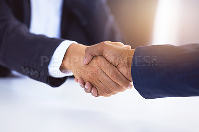 Buy stock photo Shot of two unrecognizable businessmen shaking hands in a modern office