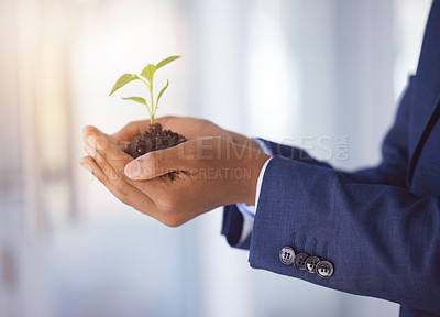 Buy stock photo .Shot of an unrecognizable businessman holding a plant growing out of soil