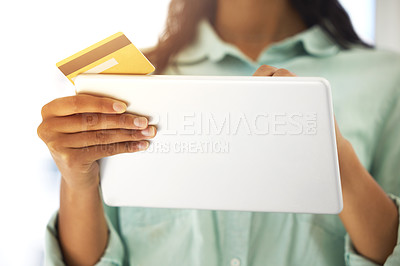 Buy stock photo Cropped shot of an unrecognizable person using a credit card and a digital tablet to shop online at home