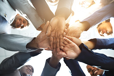 Buy stock photo Low angle shot of a diverse group of businesspeople joining their hands together