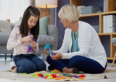 Buy stock photo Shot of a girl and her grandmother playing with toys at home