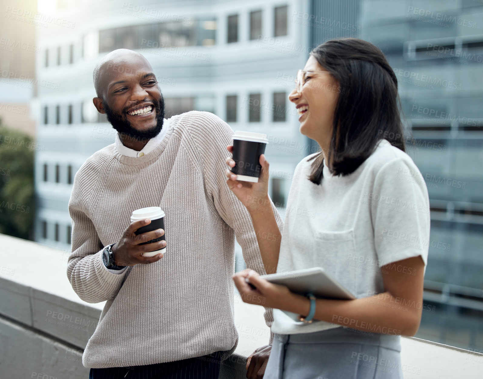 Buy stock photo Shot of two businesspeople drinking coffee together outside an office