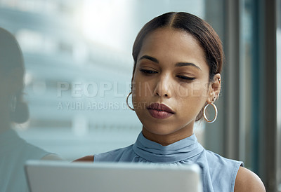 Buy stock photo Shot of a young businesswoman using a digital tablet outside an office