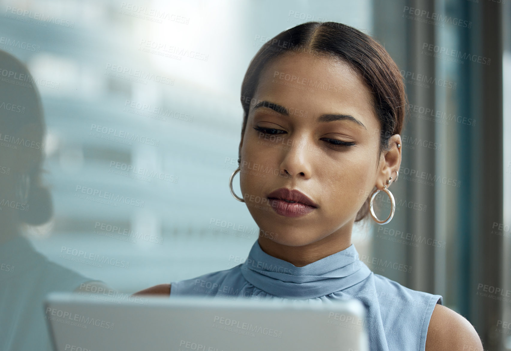 Buy stock photo Shot of a young businesswoman using a digital tablet outside an office