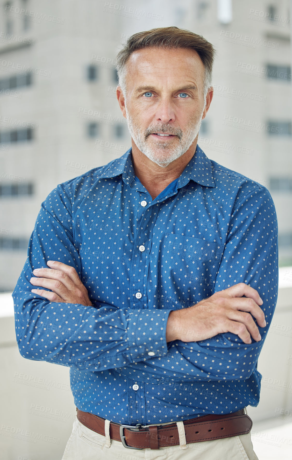 Buy stock photo Cropped portrait of a handsome mature businessman standing with his arms folded on the balcony of his office