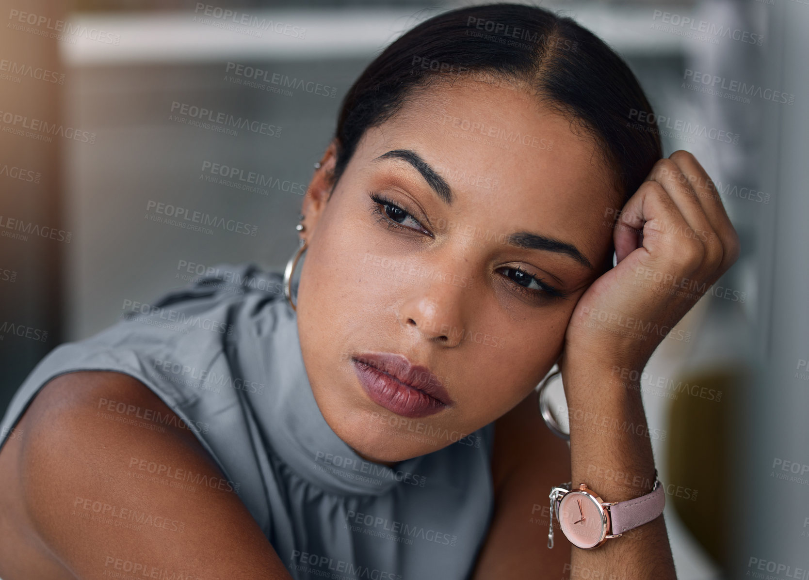 Buy stock photo Shot of an attractive young businesswoman sitting alone in the office in the evening and looking bored