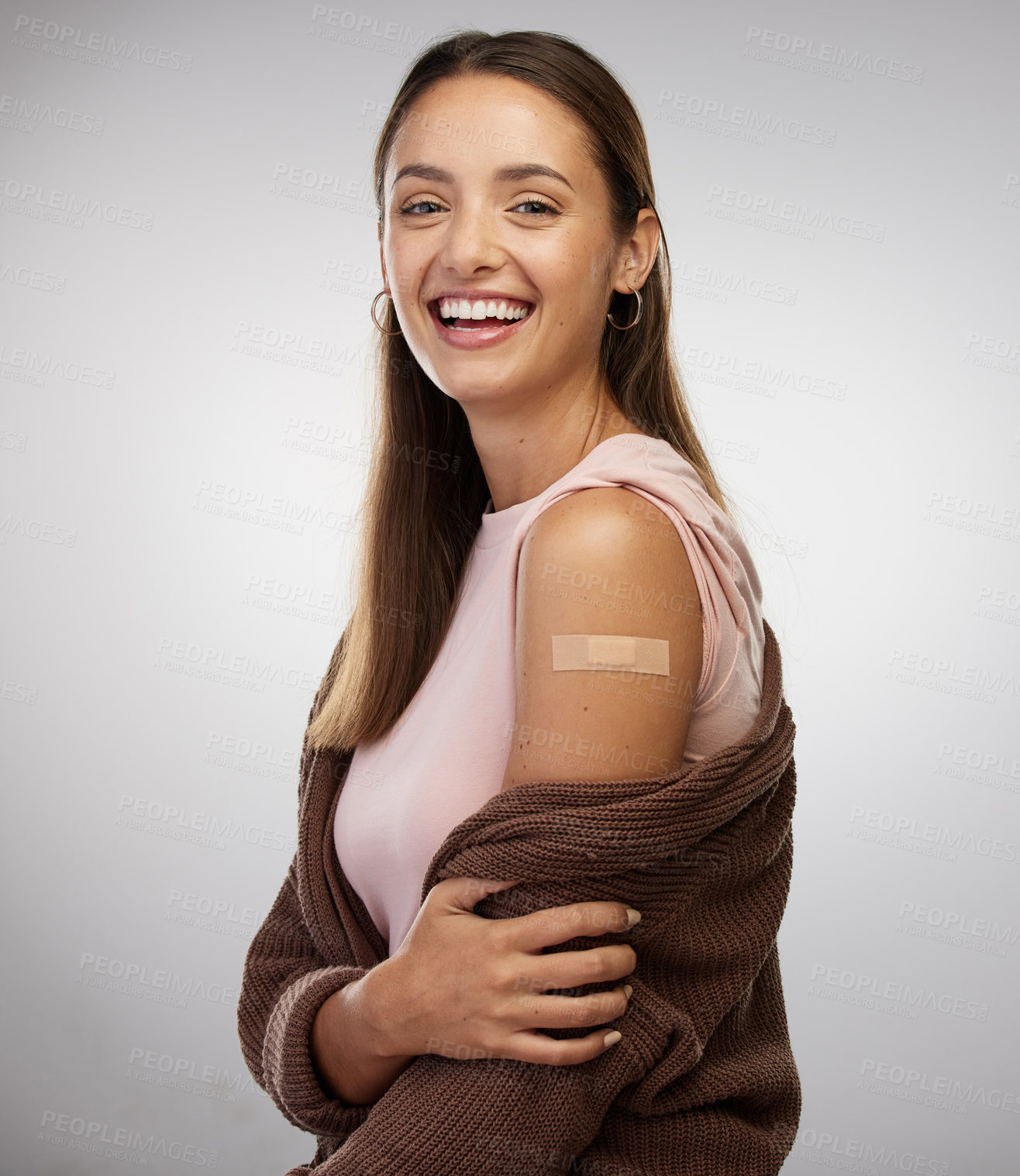 Buy stock photo Shot of a young woman standing alone in the studio after getting vaccinated