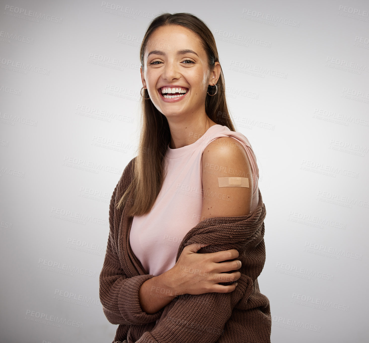 Buy stock photo Shot of a young woman standing alone in the studio after getting vaccinated