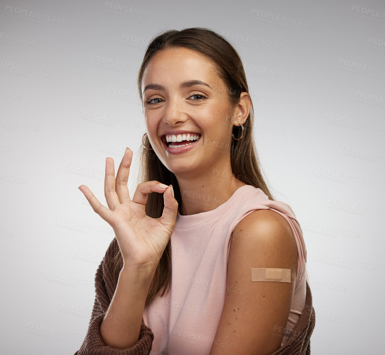 Buy stock photo Shot of a young woman standing alone in the studio after getting vaccinated