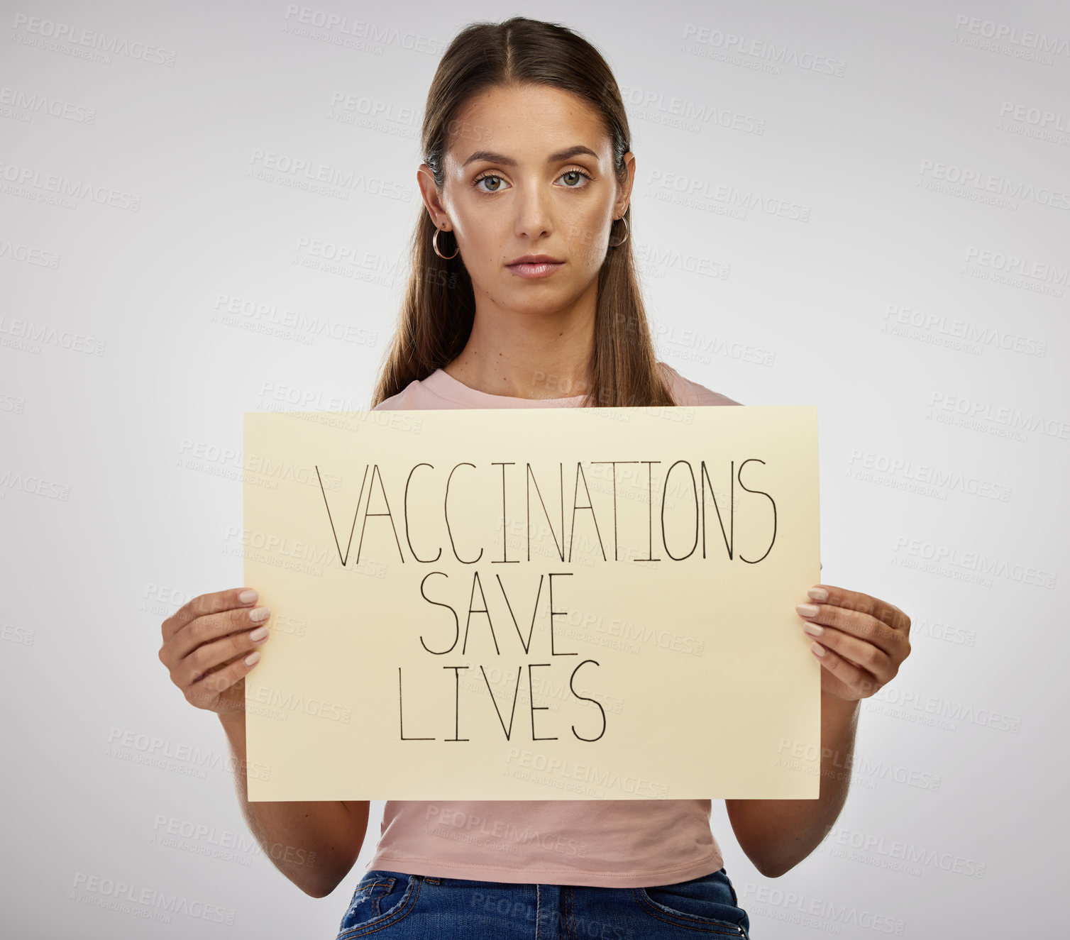 Buy stock photo Shot of a young woman standing alone in the studio and holding a poster after getting vaccinated