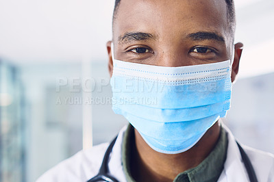 Buy stock photo Cropped portrait of a handsome young male doctor wearing a mask while standing in the hospital
