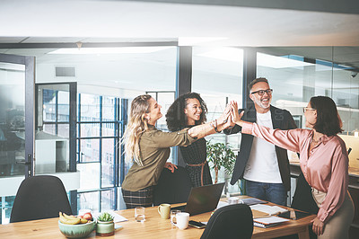 Buy stock photo Shot of a diverse group of businesspeople giving each other a high five during a meeting in the office