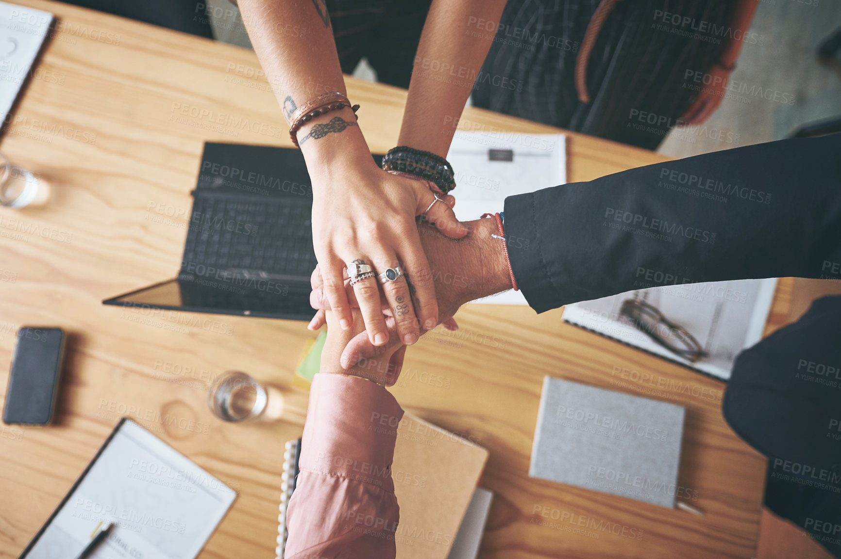 Buy stock photo High angle shot of an unrecognizable group of businesspeople standing in the office with their hands stacked in the middle