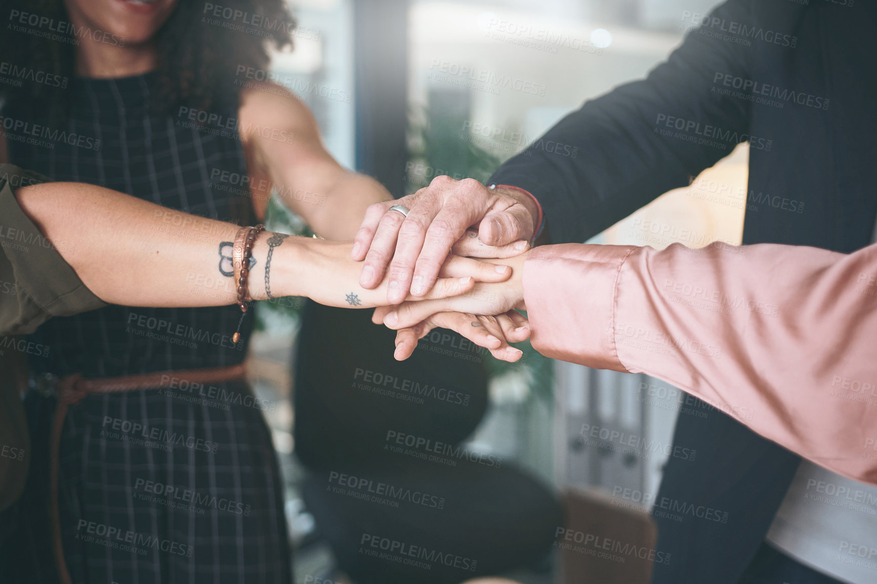 Buy stock photo Shot of an unrecognizable group of businesspeople standing in the office with their hands stacked in the middle