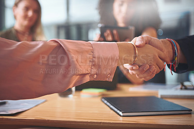 Buy stock photo Cropped shot of two unrecognizable businesspeople sitting and shaking hands in the office during a meeting