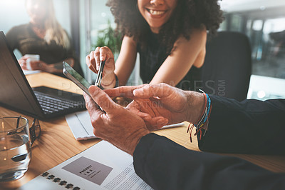 Buy stock photo Cropped shot of two unrecognizable businesspeople sitting together in the office and having a discussion while using a digital tablet