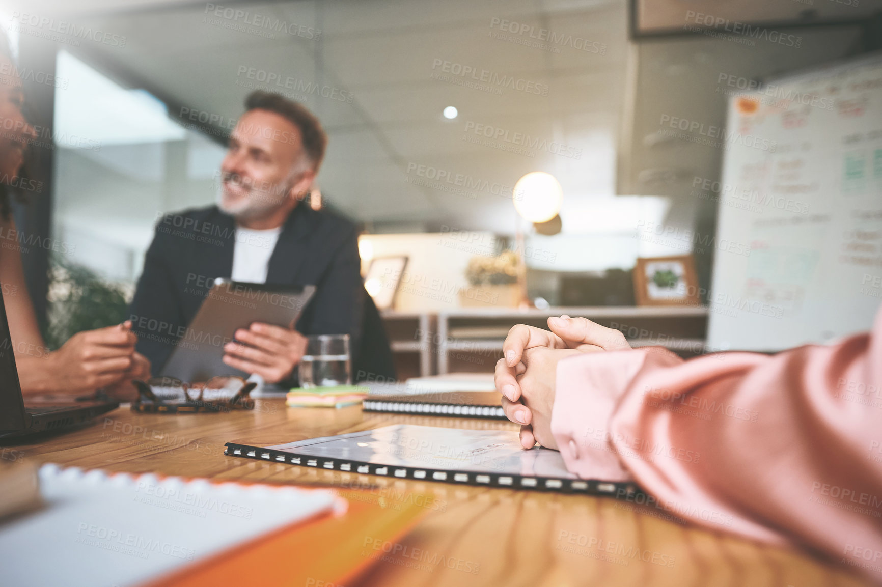 Buy stock photo Shot of two businesspeople sitting together in the office and having a discussion while using a digital tablet