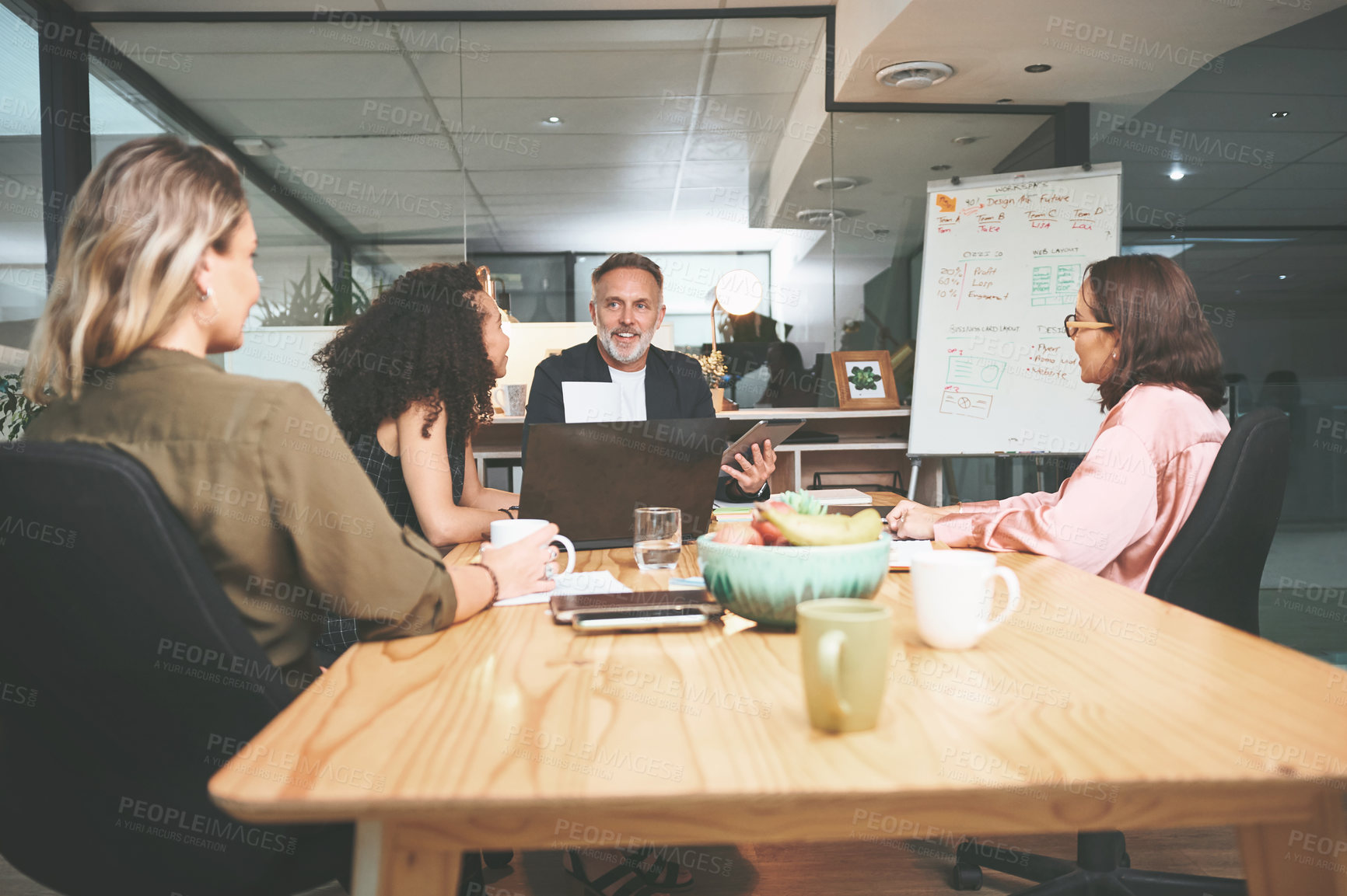 Buy stock photo Shot of a diverse group of businesspeople sitting together in the office and having a meeting