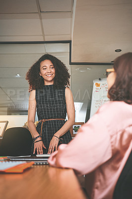 Buy stock photo Shot of two young businesswomen having a discussion in the office during a meeting