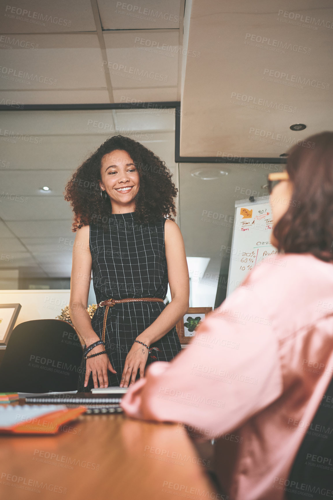 Buy stock photo Shot of two young businesswomen having a discussion in the office during a meeting