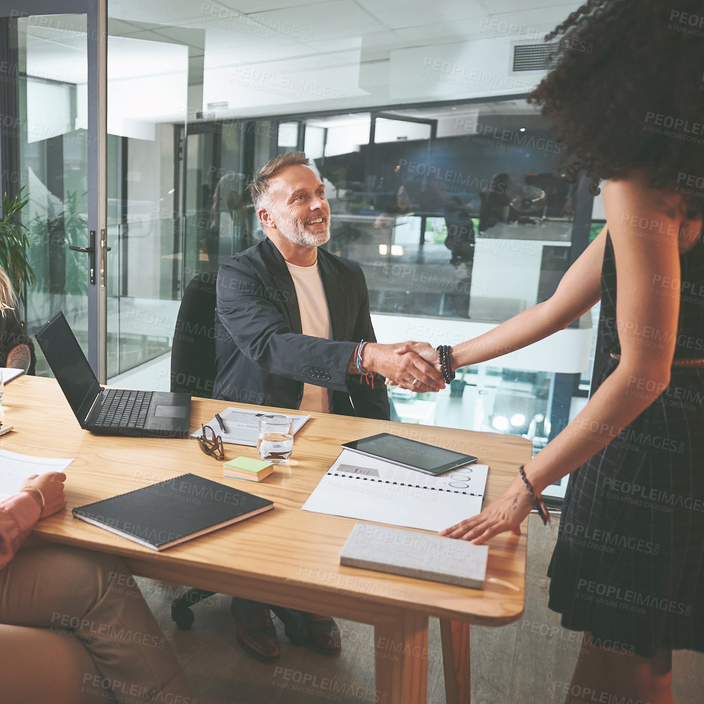 Buy stock photo Shot of two businesspeople shaking hands during a meeting in the office