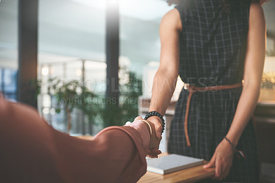 Buy stock photo Cropped shot of two unrecognizable businesspeople shaking hands during a meeting in the office