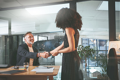 Buy stock photo Shot of two businesspeople shaking hands during a meeting in the office