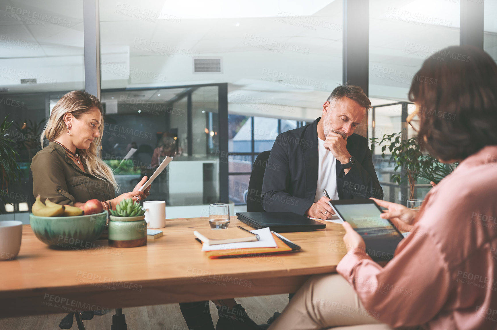 Buy stock photo Shot of a diverse group of businesspeople sitting together in the office and planning during a meeting