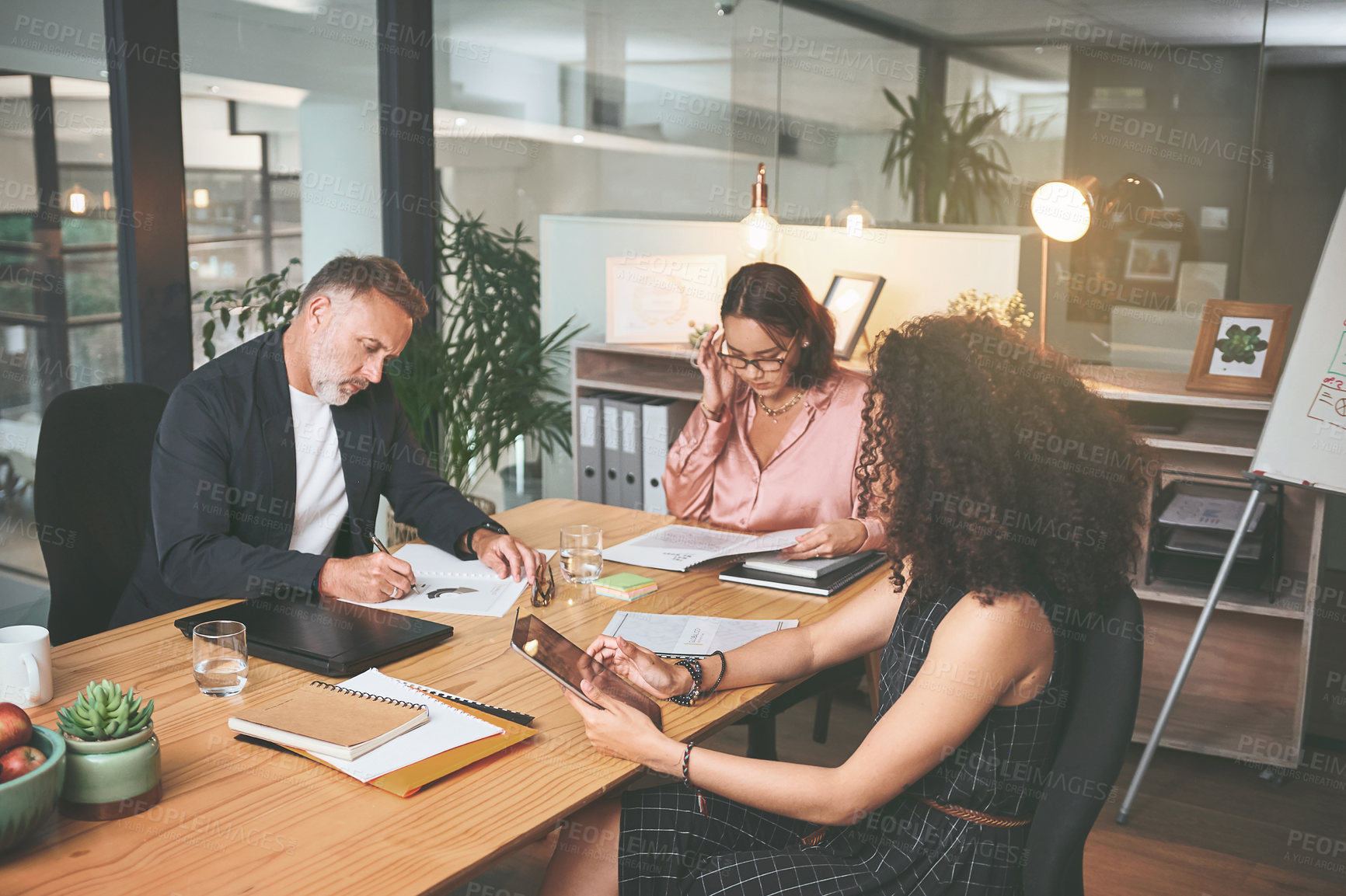 Buy stock photo Shot of a diverse group of businesspeople sitting together in the office and planning during a meeting