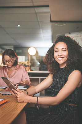 Buy stock photo Shot of an attractive young businesswoman sitting and using a digital tablet during a meeting in the office