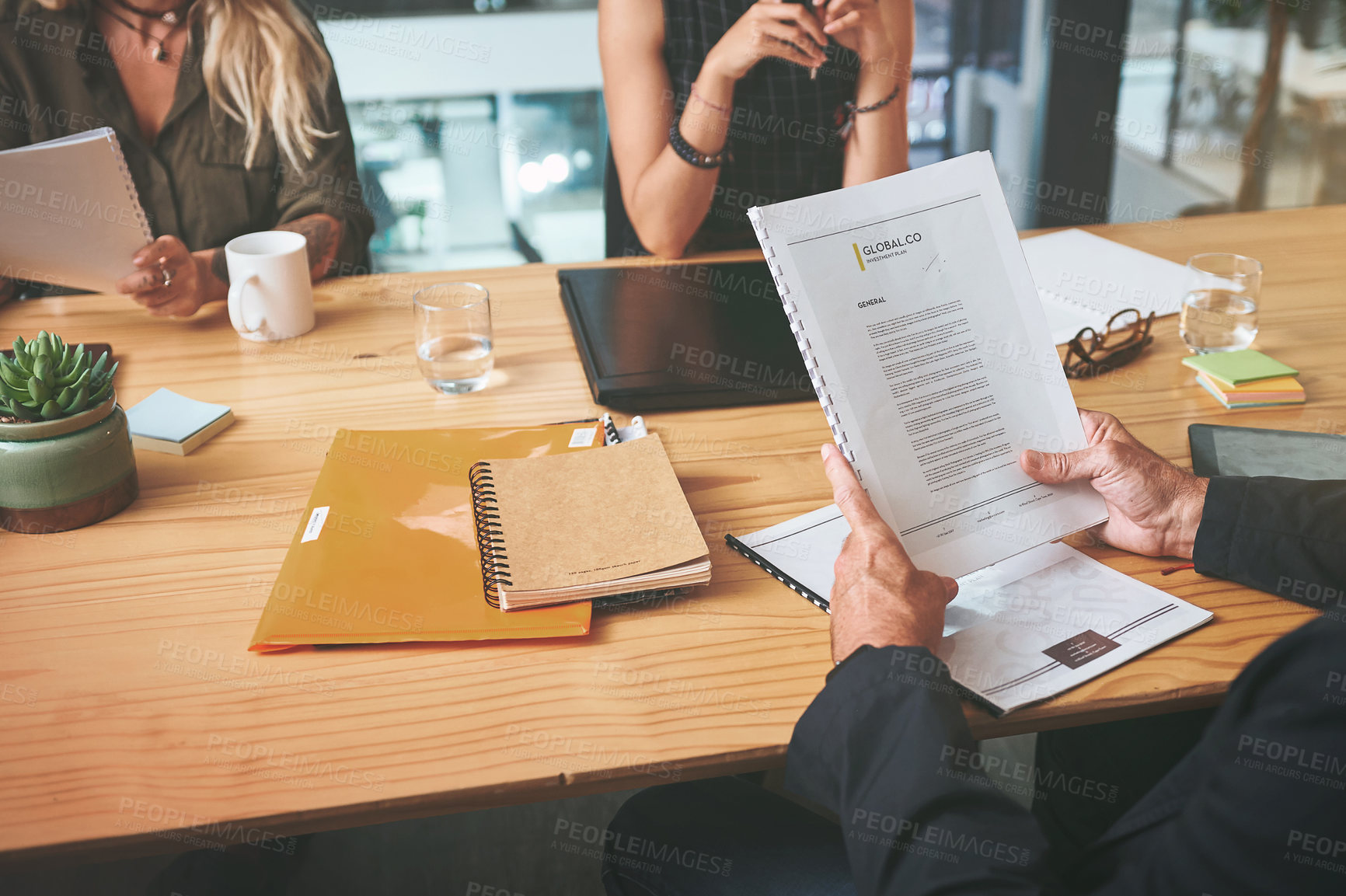 Buy stock photo Cropped shot of an unrecognizable group of businesspeople sitting together in the office and planning during a meeting