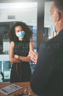 Buy stock photo Shot of two businesspeople having a discussion during a meeting in the office while wearing face masks