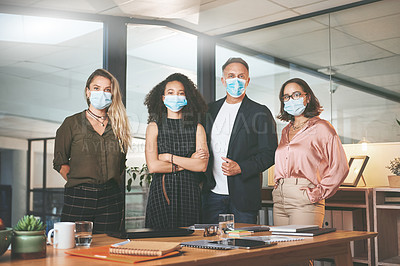 Buy stock photo Shot of a diverse group of businesspeople standing together in the office and wearing face masks