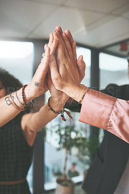 Buy stock photo Cropped shot of an unrecognizable group of businesspeople standing together and giving each other a high five in the office