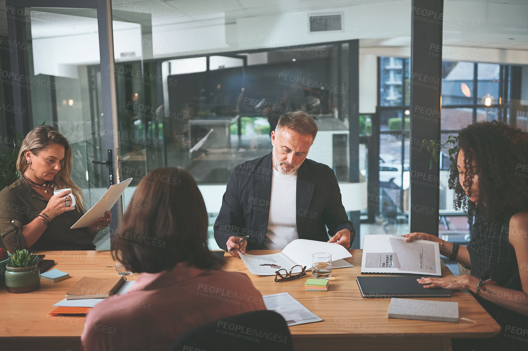 Buy stock photo Shot of a diverse group of businesspeople sitting together in the office and planning during a meeting