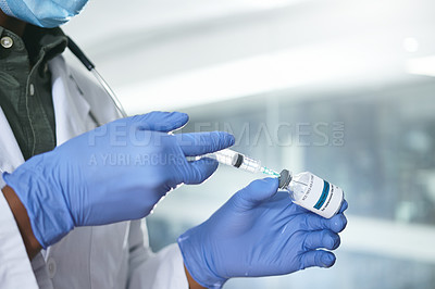 Buy stock photo Shot of an unrecognizable doctor extracting liquid with a syringe from a vial in an office