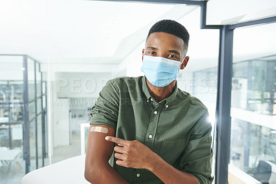 Buy stock photo Shot of a young man showing his arm in an office