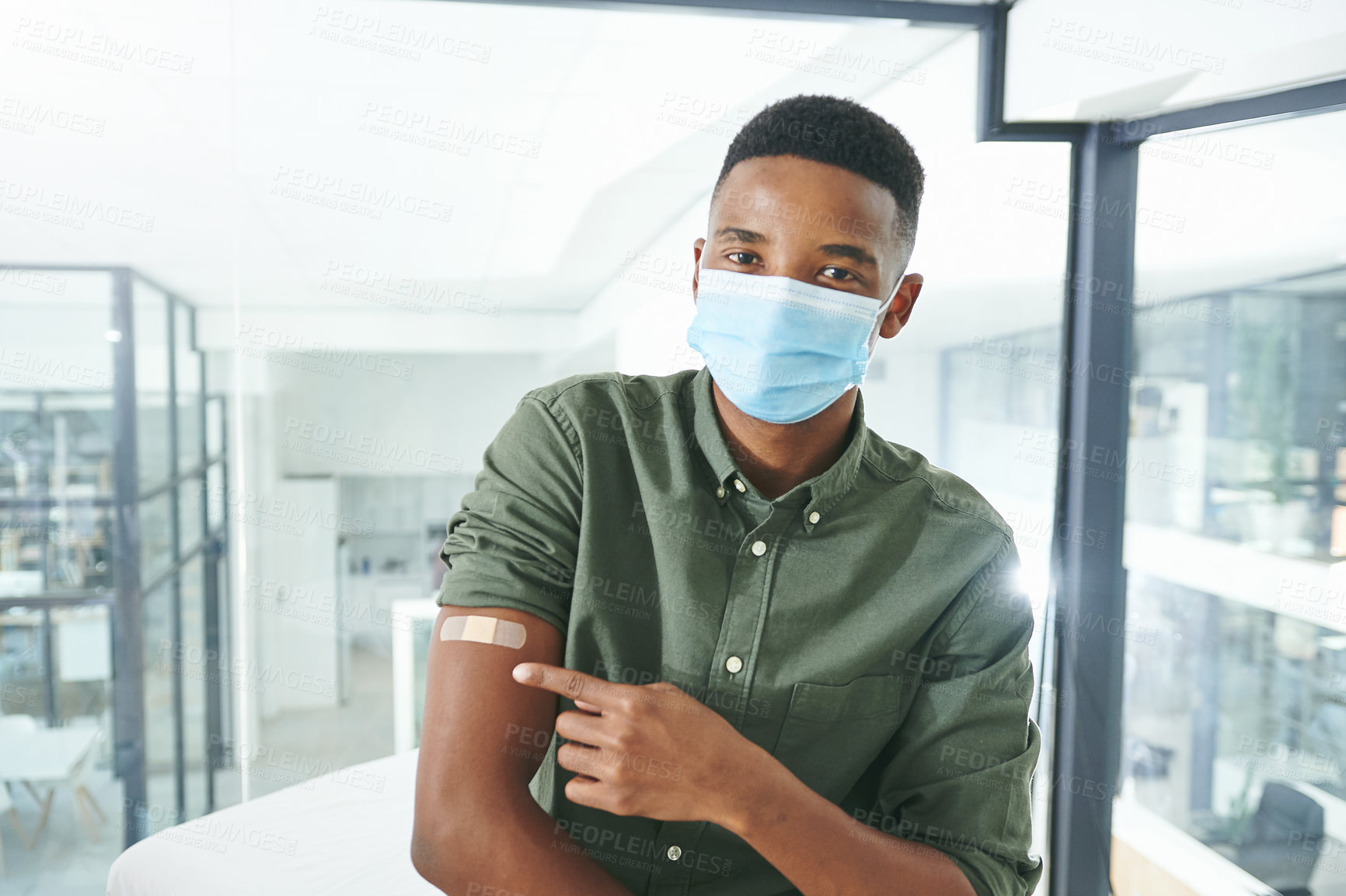 Buy stock photo Shot of a young man showing his arm in an office