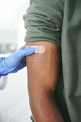 Buy stock photo Shot of an unrecognizable doctor applying a band-aid to a patient's arm