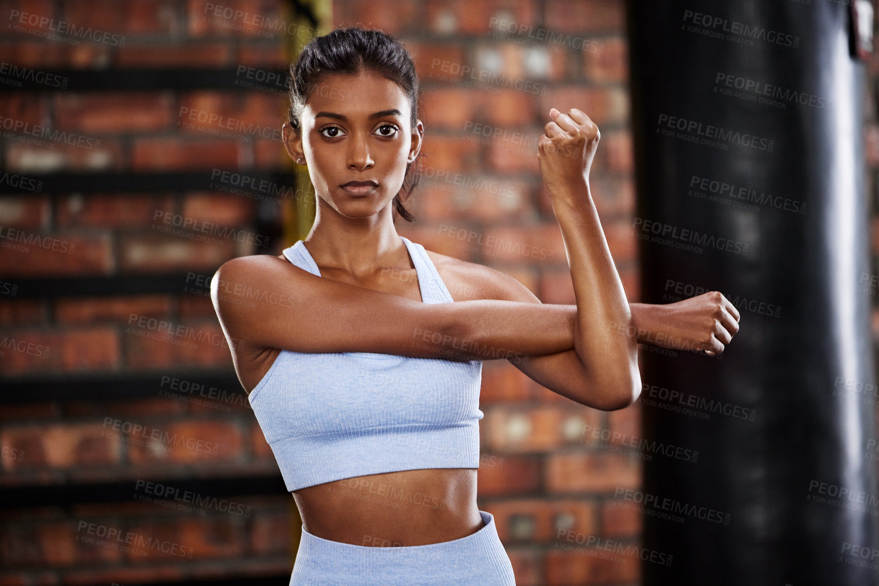Buy stock photo Shot of a sporty young woman working out at the gym