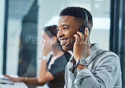 Buy stock photo Shot of a young call centre agent on a call in an office