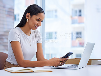 Buy stock photo Cropped shot of an attractive young businesswoman sending a text while sitting at her desk in the office